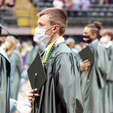 male graduate with hand over heart